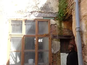 Abbröckelnde Fassade an Wohngebäude infolge von Feuchtigkeit und Witterungseinflüssen