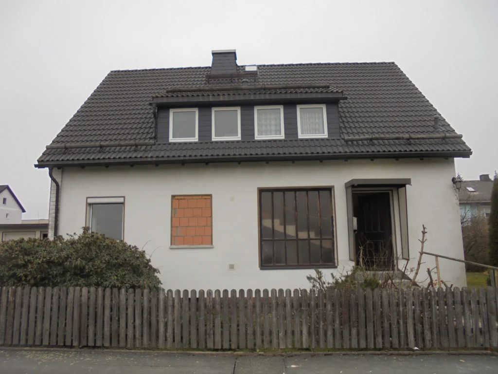 Bestandsgebäude Einfamilienhaus vor energetischer Sanierung mit ungedämmter Fassade und älteren Fenstern