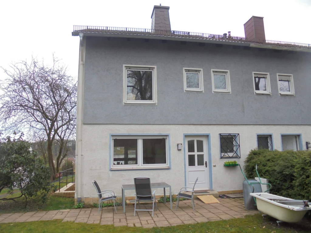 Zweifamilienhaus im Bestand vor Effizienzhaussanierung mit ungedämmter Fassade und älteren Fenstern