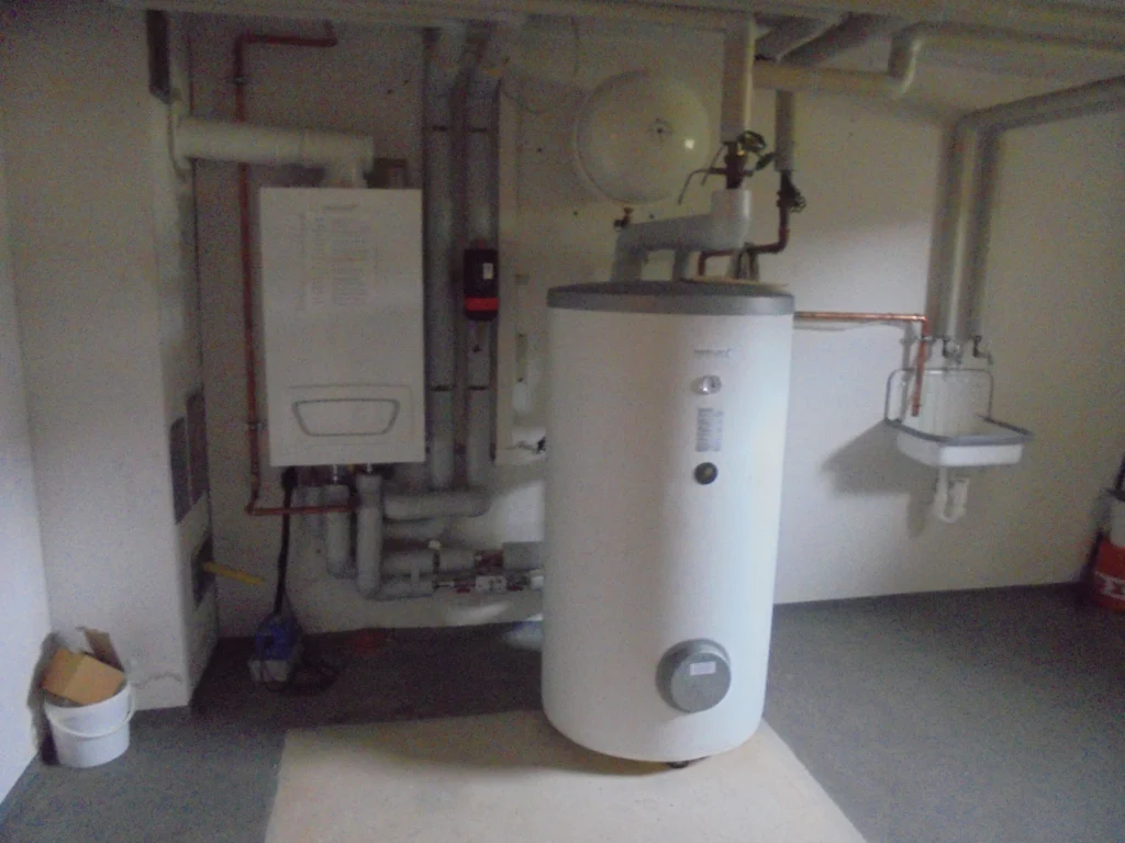 Heizungsanlage im Keller nach Heizungsoptimierung in Bad Steben mit Warmwasserspeicher und Regeltechnik